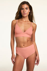 Against a neutral studio backdrop, Gianna wears the Bliss Triangle Bralette in Cabana with matching underwear, highlighting the triangle silhouette, wide comfort band, and smooth fit.