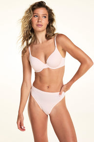 On a light studio backdrop, Alexis wears the Cloud Cotton T-Shirt Bra in Dogwood paired with matching underwear. The back view highlights the smooth back band, adjustable straps, and hook-and-eye closure. sizing: Alexis wears size 34B