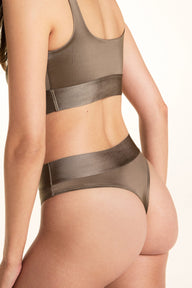 In a studio setting, Laura wears the Stretch Satin Square Neck Bralette and Stretch Satin Highwaist Thong in Sable, showing the square-neck bralette, thin straps, longline body, and high-waisted thong.