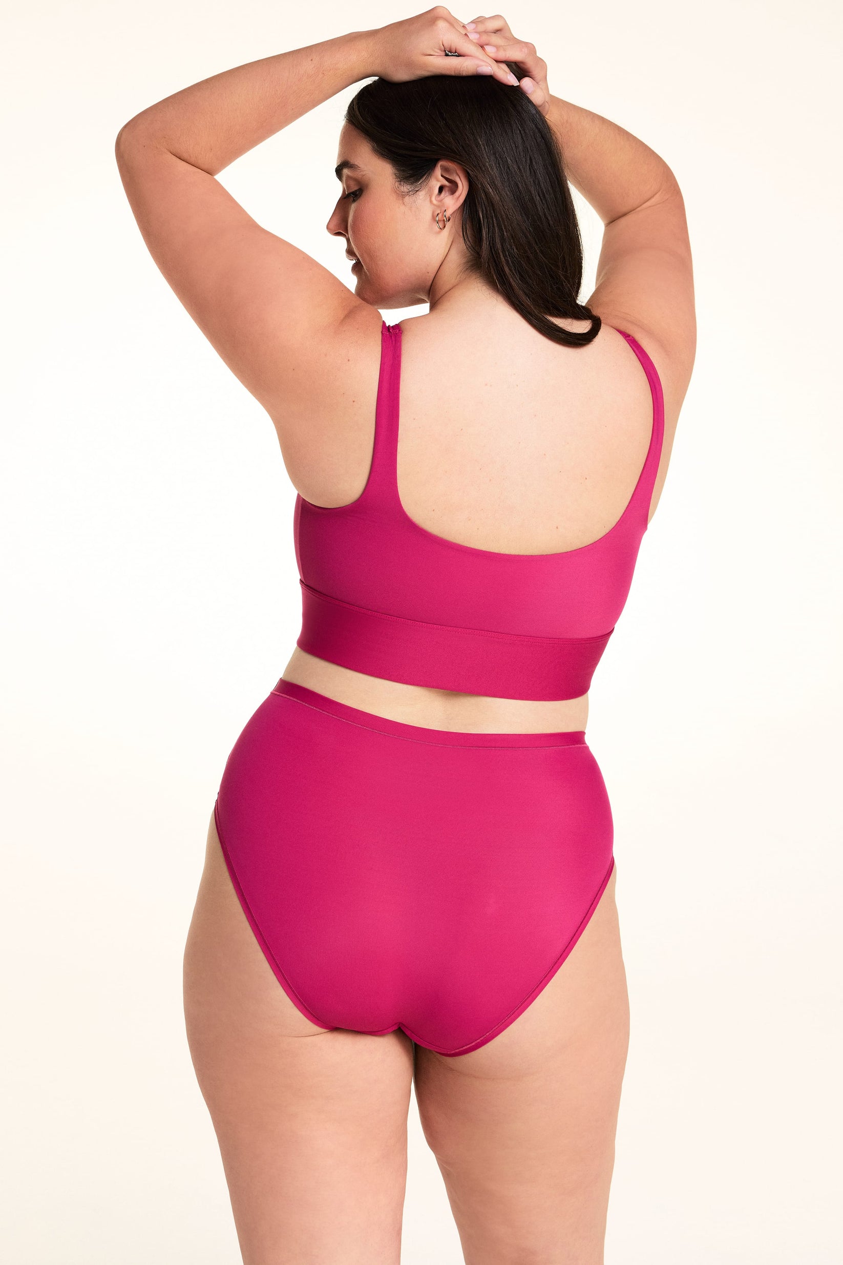 On a light studio backdrop, Alessandra wears the Bliss Highwaist underwear in Winterberry paired with the Bliss Square Bralette. The back view showcases the high-rise fit, smooth fabric, and full back coverage.