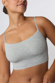 In a studio setting, India wears the Cloud Cotton Thin Strap Bralette in Heather Grey with matching underwear. The close-up view highlights the straight neckline, thin adjustable straps, and wide underband.