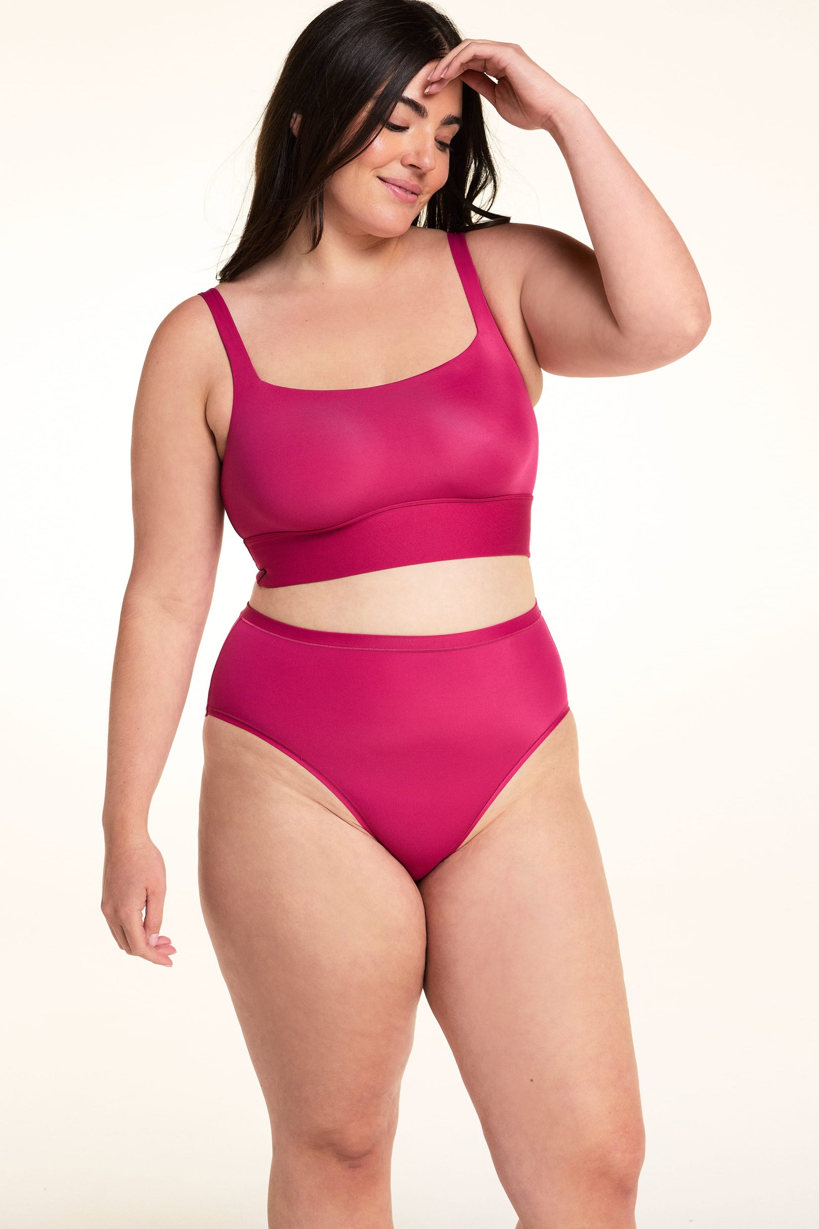 On a light studio backdrop, Alessandra wears the Bliss Highwaist underwear in Winterberry paired with the Bliss Square Bralette. The full-body image highlights the high-rise silhouette, smooth fabric, and full-coverage design.