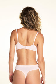 On a light studio backdrop, Alexis wears the Cloud Cotton T-Shirt Bra in Dogwood paired with matching underwear. The close-up angled view highlights the smooth molded cups, underwire support, and clean neckline.