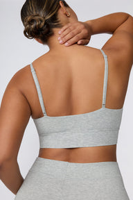 In a studio setting, Courtney wears the Cloud Cotton Triangle Bralette in Heather Grey. The close-up view highlights the soft cotton fabric, deep V-neckline, and wide underband.