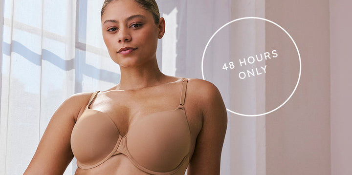 Model seated in natural light wears the Base T-Shirt Bra in tan and coordinating bottoms. White circular text overlay reads: “48 HOURS ONLY.”
