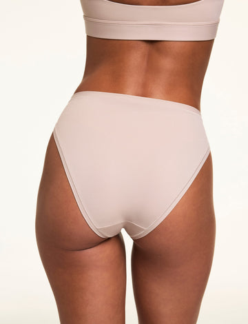 From the back, Linni wears the Bliss French Cut Brief in Pebble, highlighting the smooth microfiber fabric and moderate back coverage.