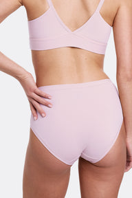 In a studio setting with a neutral backdrop, Gianna wears the Bliss Triangle Bralette and Bliss Highwaist Brief in Retro Lilac, shown from the back in a close-up view. The underwear features a high-rise silhouette, ultra-soft microfiber fabric, and an elastic-free design that sits smoothly against the skin. sizing: Gianna wears size Small