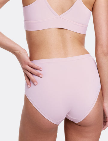 In a studio setting with a neutral backdrop, Gianna wears the Bliss Triangle Bralette and Bliss Highwaist Brief in Retro Lilac, shown from the back in a close-up view. The underwear features a high-rise silhouette, ultra-soft microfiber fabric, and an elastic-free design that sits smoothly against the skin. sizing: Gianna wears size Small