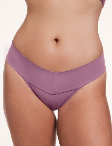 In a studio setting, a model wears the Bliss Low Rise Thong in Mirage, shown in a close-up front view. The thong features a low-rise fit, minimal coverage, and smooth, seamless fabric.
sizing: Sonnie wears size Large