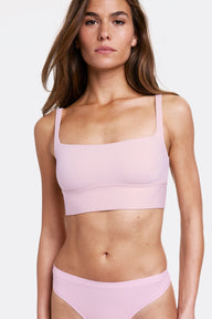 In a studio setting with a light gray backdrop, Gianna wears the Bliss Square Neck Bralette in Retro Lilac with matching underwear, featuring a square neckline and a longline silhouette. The bralette has thin adjustable straps and a soft wireless band for comfortable support, made from smooth microfiber fabric.  sizing: Gianna wears size Small