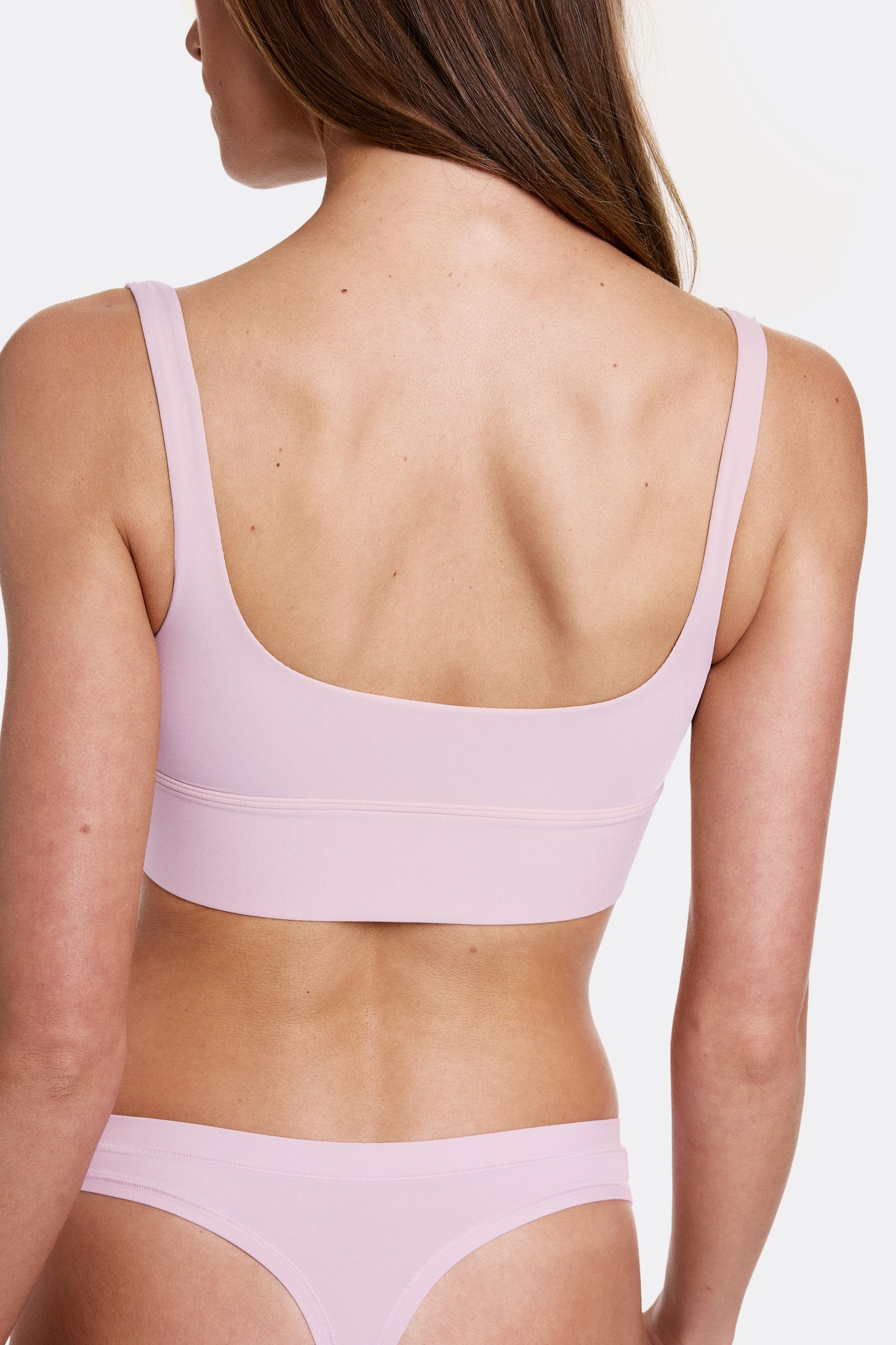 In a studio setting with a light gray backdrop, Gianna wears the Bliss Square Neck Bralette in Retro Lilac, shown from the back to highlight the scoop back and longline design. Thin adjustable straps and a soft wireless band provide a comfortable, flexible fit.