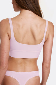 In a studio setting with a light gray backdrop, Gianna wears the Bliss Square Neck Bralette in Retro Lilac, shown from the back to highlight the scoop back and longline design. Thin adjustable straps and a soft wireless band provide a comfortable, flexible fit.