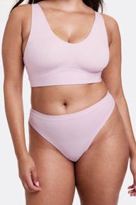 In a studio setting with a neutral backdrop, Alana wears the Bliss Scoop Bralette and Bliss Thong in Retro Lilac. The bralette features a scoop neckline, wireless band for support, and ultra-soft microfiber fabric, paired with a smooth, low-rise thong with an elastic-free design. sizing: Alana wears size Large