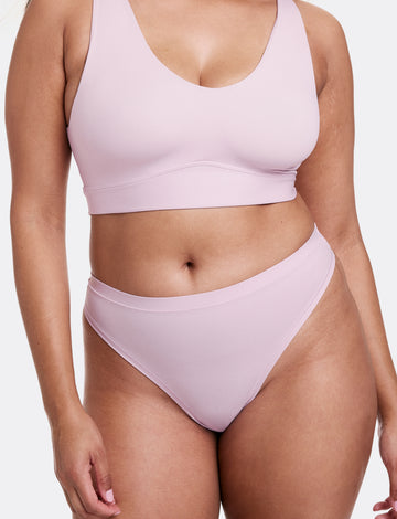 In a studio setting with a neutral backdrop, Alana wears the Bliss Scoop Bralette and Bliss Thong in Retro Lilac. The bralette features a scoop neckline, wireless band for support, and ultra-soft microfiber fabric, paired with a smooth, low-rise thong with an elastic-free design. sizing: Alana wears size Large