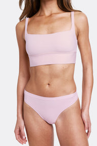 In a studio setting with a neutral backdrop, Gianna wears the Bliss Square Neck Bralette and Bliss Thong in Retro Lilac. The bralette features a square neckline, wireless band for support, and ultra-soft microfiber fabric, paired with a smooth, low-rise thong with an elastic-free design.