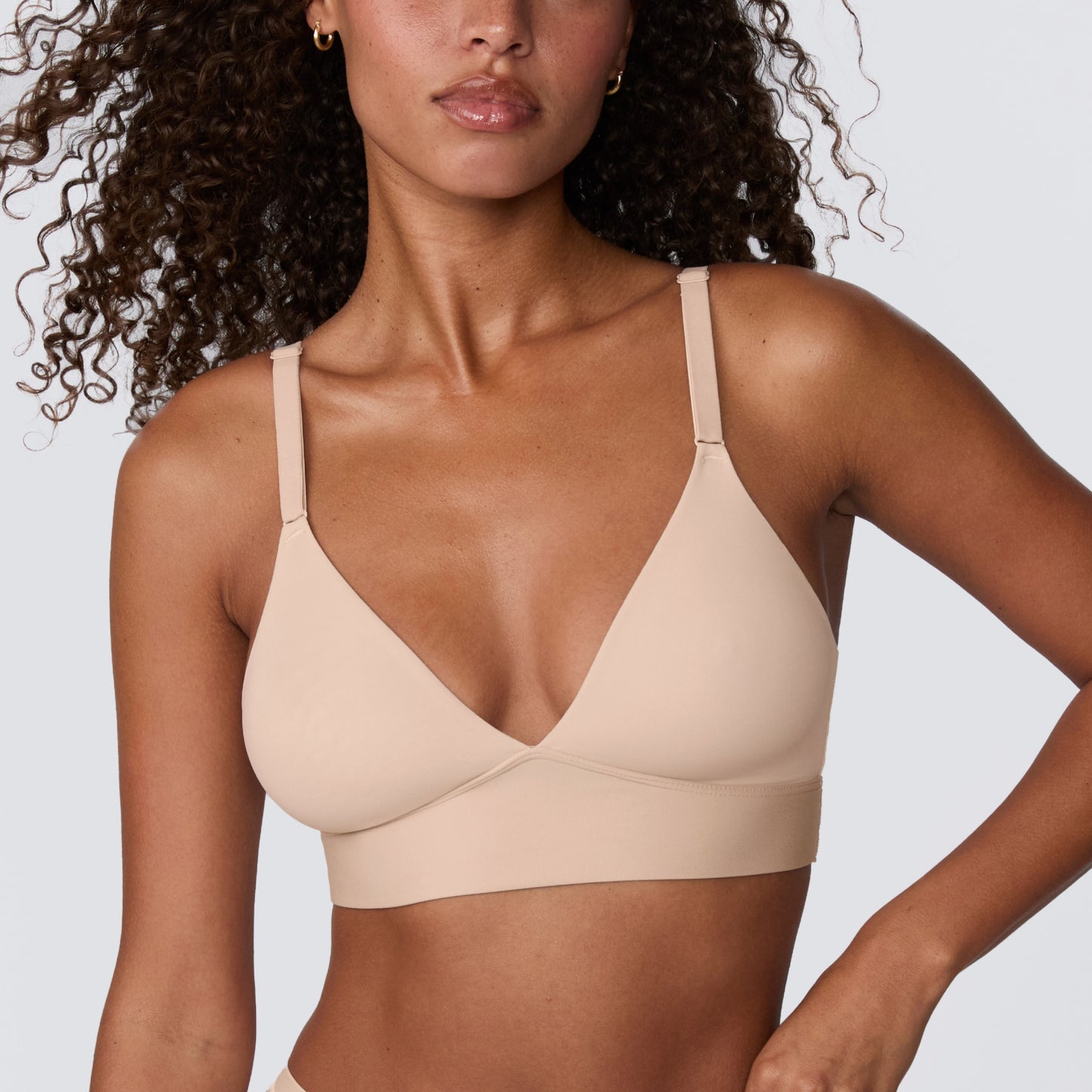 Close-up of model wearing the Harper Wilde Bliss Triangle wireless bralette in beige, featuring the soft triangle cups and smooth microfiber band.