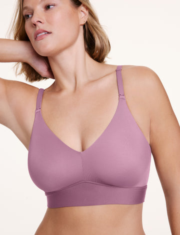 In a studio setting, Sonnie wears the Bliss Triangle Bralette in Mirage, shown in a close-up with a deep V neckline, wireless cups, and a wide underband. The soft fabric and adjustable straps provide lightweight support. sizing: Sonnie wears size XL