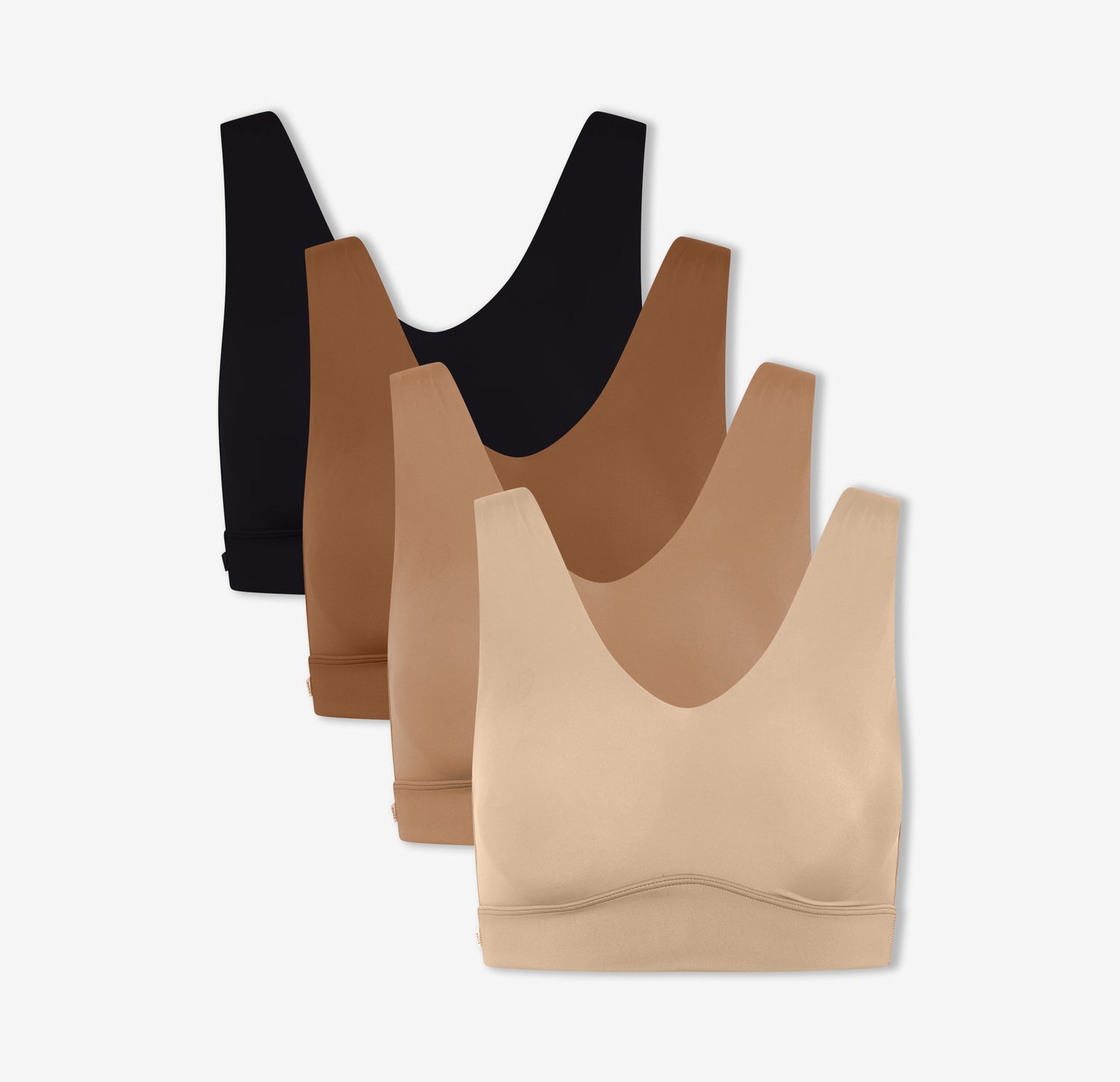 Four of Harper Wilde's Bliss Bralettes in Black, Brown, Tan, and Beige which offer ultra-soft wireless support and comfort.