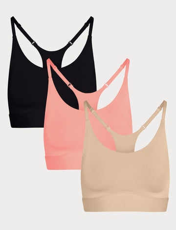 Three Bliss Racerback Bralettes in Black, Cabana, and Beige displayed on a light grey background, showing the adjustable racerback straps.