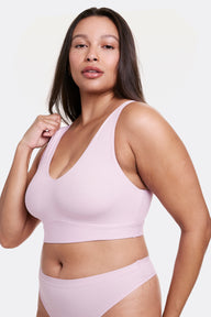 Angled view of Alana wearing a Retro Lilac V-neck bralette with wide straps and a seamless construction, paired with matching underwear. sizing: Alana is wearing size Large