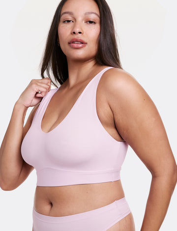 Angled view of Alana wearing a Retro Lilac V-neck bralette with wide straps and a seamless construction, paired with matching underwear. sizing: Alana is wearing size Large