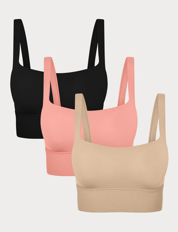 Three Bliss Squareneck Bralettes in Black, Cabana, and Beige displayed on a light grey background, showing the wide square neckline and thick shoulder straps.