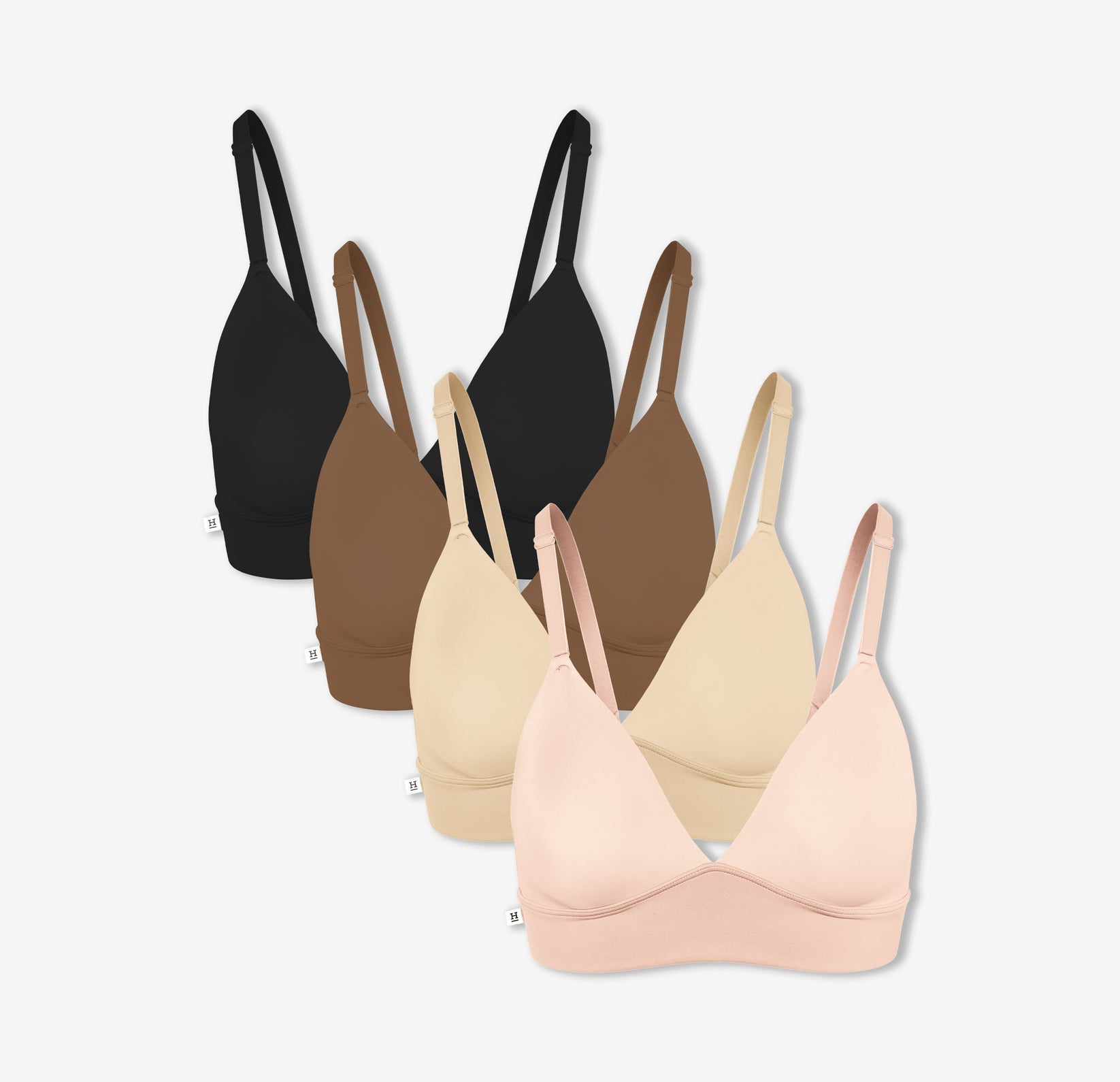Four of Harper Wilde Bliss Triangle Bralettes in Rose, Beige, Brown, and Black— offering wireless support and comfort.