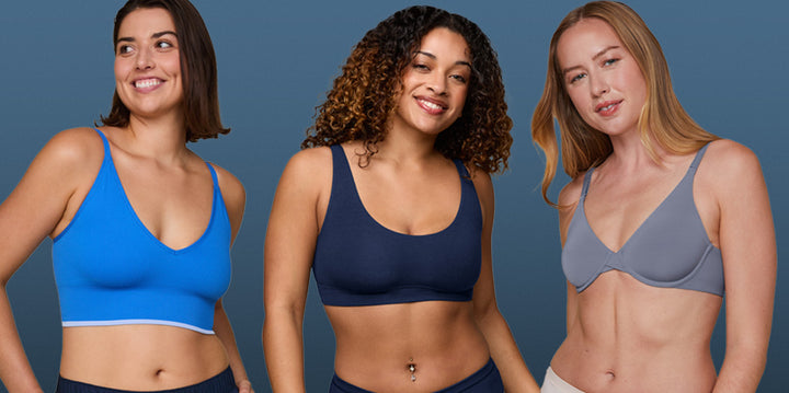 Three models wearing Harper Wilde bras in shades of blue. The first model is wearing the Lounge Triangle Bralette in Bluebird, the second model is in the Cloud Cotton Scoop in Midnight, and the third model is in the Base Unlined Bra in Steel. The image showcases the variety of styles and shades of blue available.