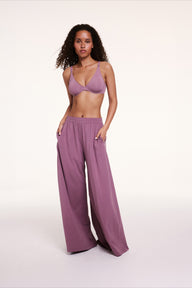 In a studio setting, Courtney wears a lightly lined underwire bra paired with Cloud Cotton pants in Mirage, showing the smooth cups, adjustable straps, and relaxed wide-leg fit with side pockets.