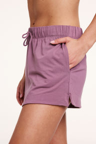 In a studio setting, Gianna wears Cloud Cotton shorts in Mirage, showing the side pocket, elastic waistband with drawstring, and soft, lightweight fabric.