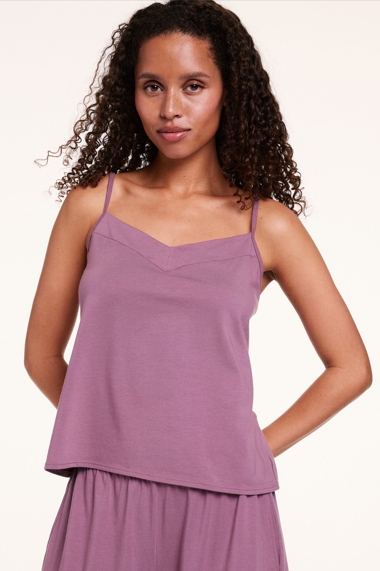 In a studio setting, Courtney wears the Cloud Cotton tank in Mirage, featuring a soft V-neckline, thin adjustable straps, and lightweight, breathable fabric. sizing: Courtney wears size Small