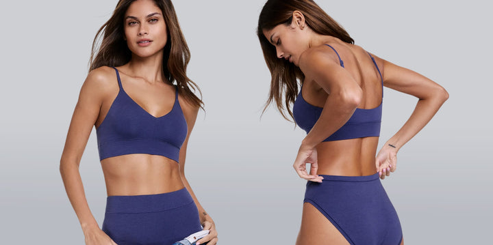 On a studio backdrop, a model wears the Cloud Cotton Triangle Bralette and matching bottoms in blue, showing the deep V-neck, adjustable straps, and soft cotton modal fabric.