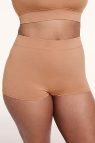 On a light studio backdrop, Alana wears the Cloud Cotton Boyshort in Dune, shown in a front close-up. The boyshort features a high-rise waistband, full coverage, and soft, breathable fabric. sizing: Alana wears size Large