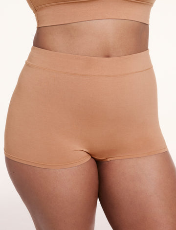 On a light studio backdrop, Alana wears the Cloud Cotton Boyshort in Dune, shown in a front close-up. The boyshort features a high-rise waistband, full coverage, and soft, breathable fabric. sizing: Alana wears size Large