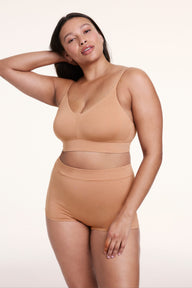 On a light studio backdrop, Alana wears the Cloud Cotton Boyshort in Dune with a matching bralette. The boyshort features a high-rise waistband, full coverage, and soft, breathable fabric.