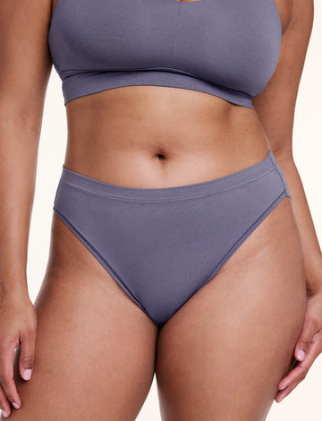 On a white studio backdrop, Alana wears the Cloud Cotton French Cut Brief in Slate, shown from the front with a high-rise waist and French cut leg opening. sizing: Alana wears size Large