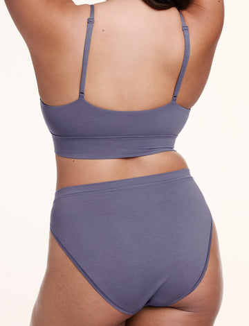 On a white studio backdrop, Alana wears the Cloud Cotton French Cut Brief in Slate with a matching bralette, shown from the back with mid- to full coverage and a smooth, stay-put fit.
