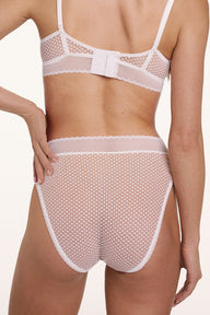 On a white studio backdrop, Gianna wears the Dot Lace Highwaist Brief in Ivory in a back view, highlighting the sheer dot lace fabric, scalloped waistband, and moderate back coverage. sizing: Gianna wears size Small