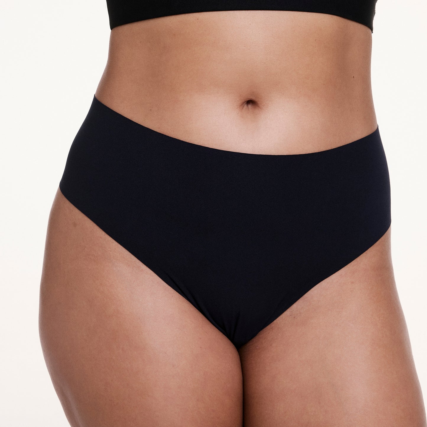 Close-up front view of the No-Show High Waist Thong in Black, highlighting the high-rise silhouette and seamless, raw-edge waistband.