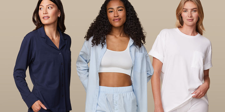 Three models showcasing Harper Wilde’s Sleep collection. The first model wears the Perfect Pima Pajamas in Navy, featuring a long-sleeve button-up top and matching pants. The second model wears the Classic Poplin Pajamas in Ice Blue, styled open over the Lounge Rib Scoop Bralette and matching pants. The third model is in the Cloud Cotton T-Shirt in white, paired with Harper Wilde’s logo boxer brief, emphasizing the soft and comfortable fit.