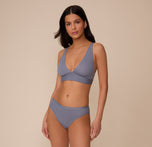 Full body shot of Marcela wearing the Bliss Plunge Adjustable Bralette and Bliss Bikini in Steel. The matching set highlights the products' everyday wearability.