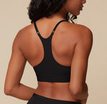 Back view of Ally in the Bliss Racerback Bralette in Black, highlighting the racerback straps and adjustable hardware for a customizable fit.