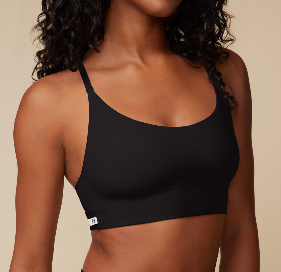 Detailed close-up of the Bliss Racerback Bralette in Black on Ally, focusing on the subtle Harper Wilde logo tag along the band, emphasizing the sleek and minimalistic design.
