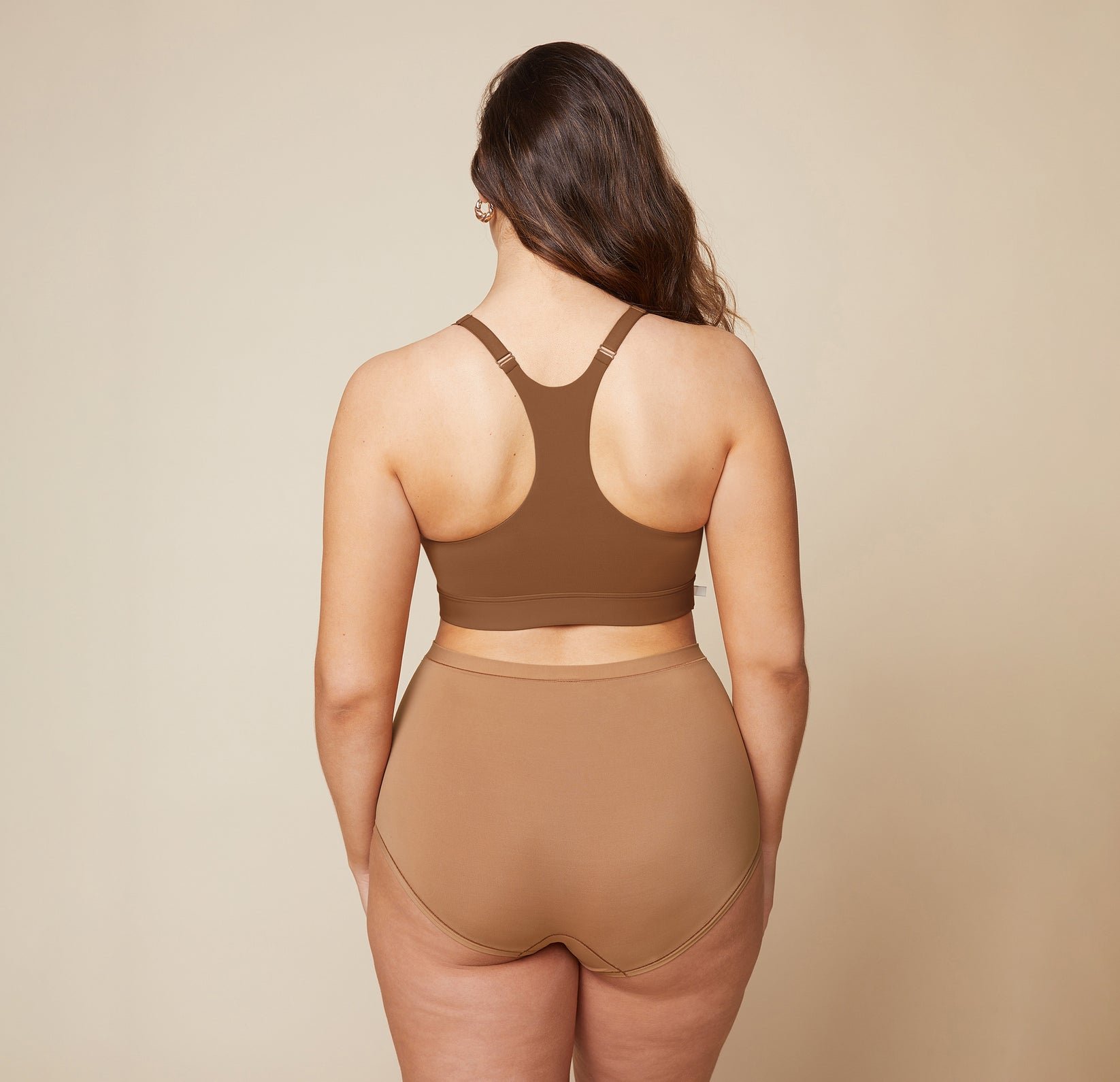 A back view of Summerlyn wearing the Bliss Racerback Bralette in Brown and the Bliss Boyshort in Tan. The image highlights the racerback design of the bralette and the full coverage provided by the boyshort.