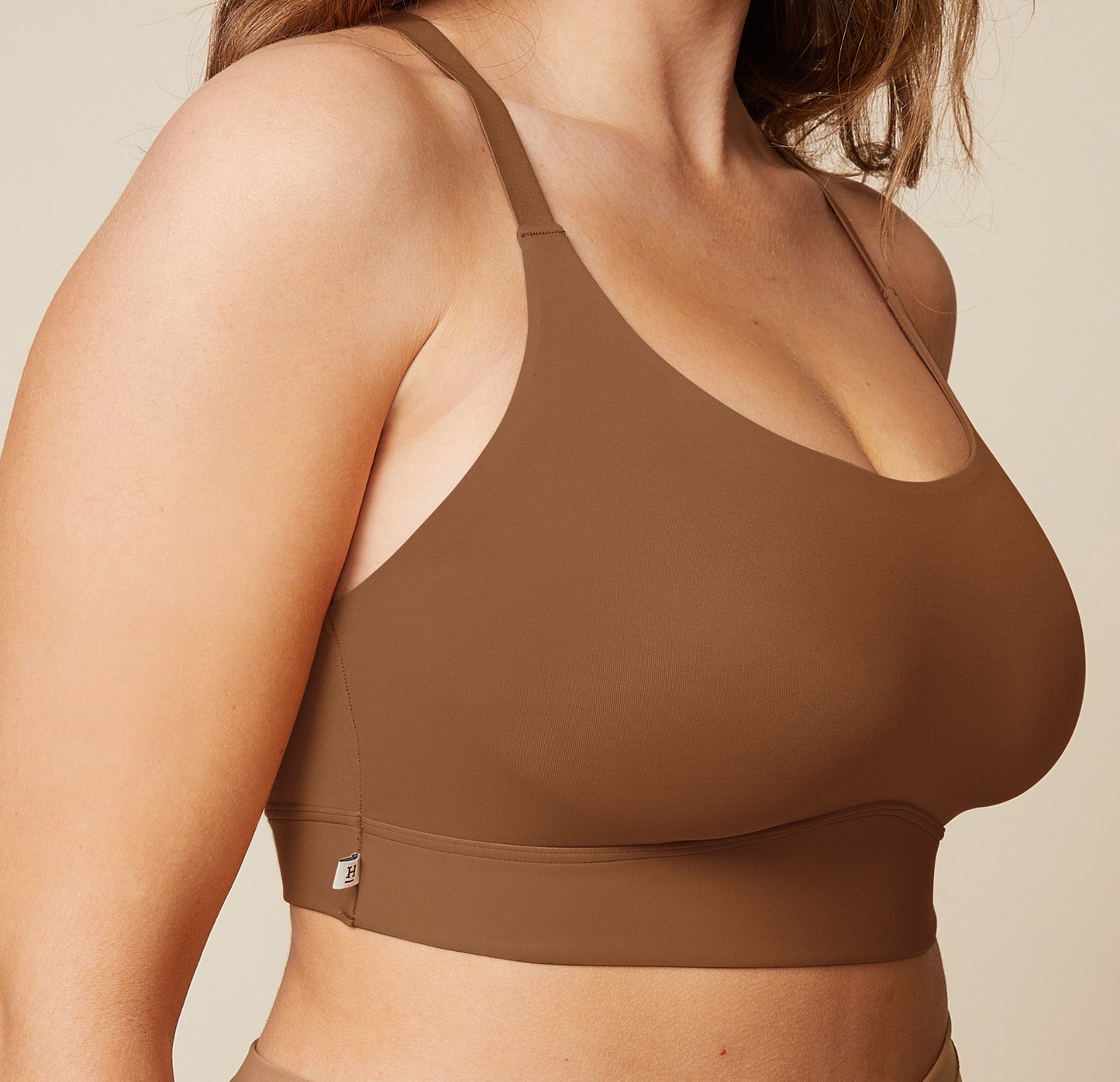 A close-up side view of the Bliss Racerback Bralette in Brown, worn by Summerlyn. The image focuses on the soft fabric and the comfortable fit of the bralette.