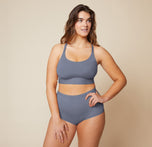 Summerlyn standing with her hand on her hip, wearing the Bliss Racerback Bralette in Steel and the Bliss Boyshort in Steel. The front view highlights the supportive fit of the bralette and the comfortable coverage of the boyshort. sizing: Summerlyn wears size Large