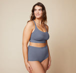 Summerlyn standing with her arms relaxed by her sides, wearing the Bliss Racerback Bralette in Steel and the Bliss Boyshort in Steel. The image shows the front view of the set, emphasizing the soft fabric and fit.