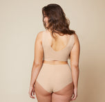 The back view of Summerlyn wearing the Bliss Sleek Lined Bralette and No-Show Highwaist Brief in Beige highlights the seamless, wireless design for a smooth, comfortable fit.