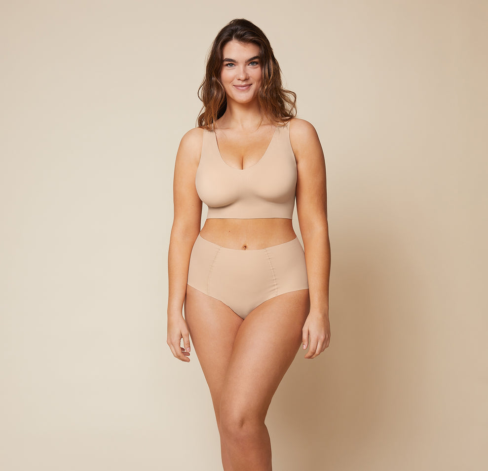 Summerlyn, wearing the Bliss Sleek Lined Bralette and No-Show Highwaist Brief in Beige, displays the bralette's wireless lift and smoothing fabric for a sleek, supportive look.