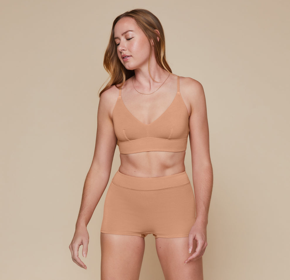 Model wearing the Cloud Cotton Triangle Bralette and matching Highwaist Cloud Cotton Boyshort in the color Dune. sizing: Erin wears size Small